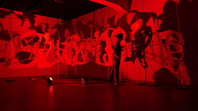 Vue de la sculpture GAFA GATE avec des projections lumineuses illustrant la fracture numérique et la surveillance en ligne